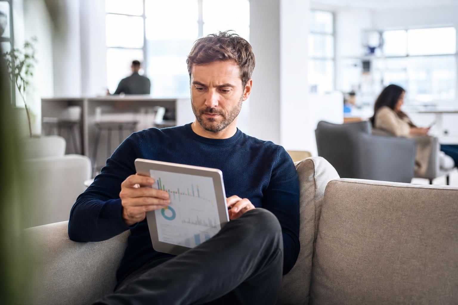 Homme consultant une tablette dans un espace de coworking lumineux